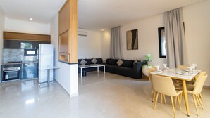 A modern living space with a kitchen, dining area, and seating area. - rose garden resort marrakech (Marrakech)