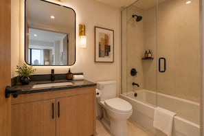 A modern bathroom with a marble countertop, a toilet, a shower with a glass enclosure, and a large mirror. - Downtown Toronto Suites - Jarvis (Toronto)