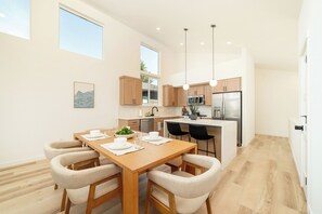 Una cocina moderna con armarios de madera, una isla central e iluminación colgante.