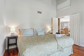 A bedroom with a bed, two bedside tables with lamps, a door leading to another room, and a visible window. - Phoenix Fairway Golf Escape | Private Pool, Fire Pit & Fairway Views 🌵⛳ (Phoenix)