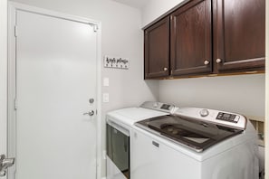 A laundry room with a white door, a sign above it, and a washing machine. - Foothills Golf Escape - Phoenix Pool House backing up to Foothills Golf Club (Phoenix)