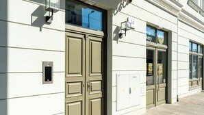 A building facade with double doors, a mailbox, and a sign indicating a bakery. - Kalwaryjska Signature Bright Studio (Kraków)