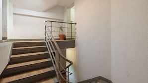 A staircase with a metal railing, a potted plant, and a skylight. - Jagiellońska Central Guest Spot #2 (Szczecin)