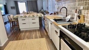 Una cocina compacta con una isla central, un fregadero y una estufa.