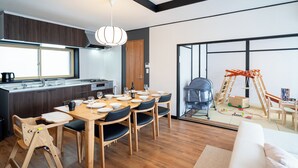 Eine moderne Küche mit Essbereich, Holzmöbeln und einem großen Fenster.