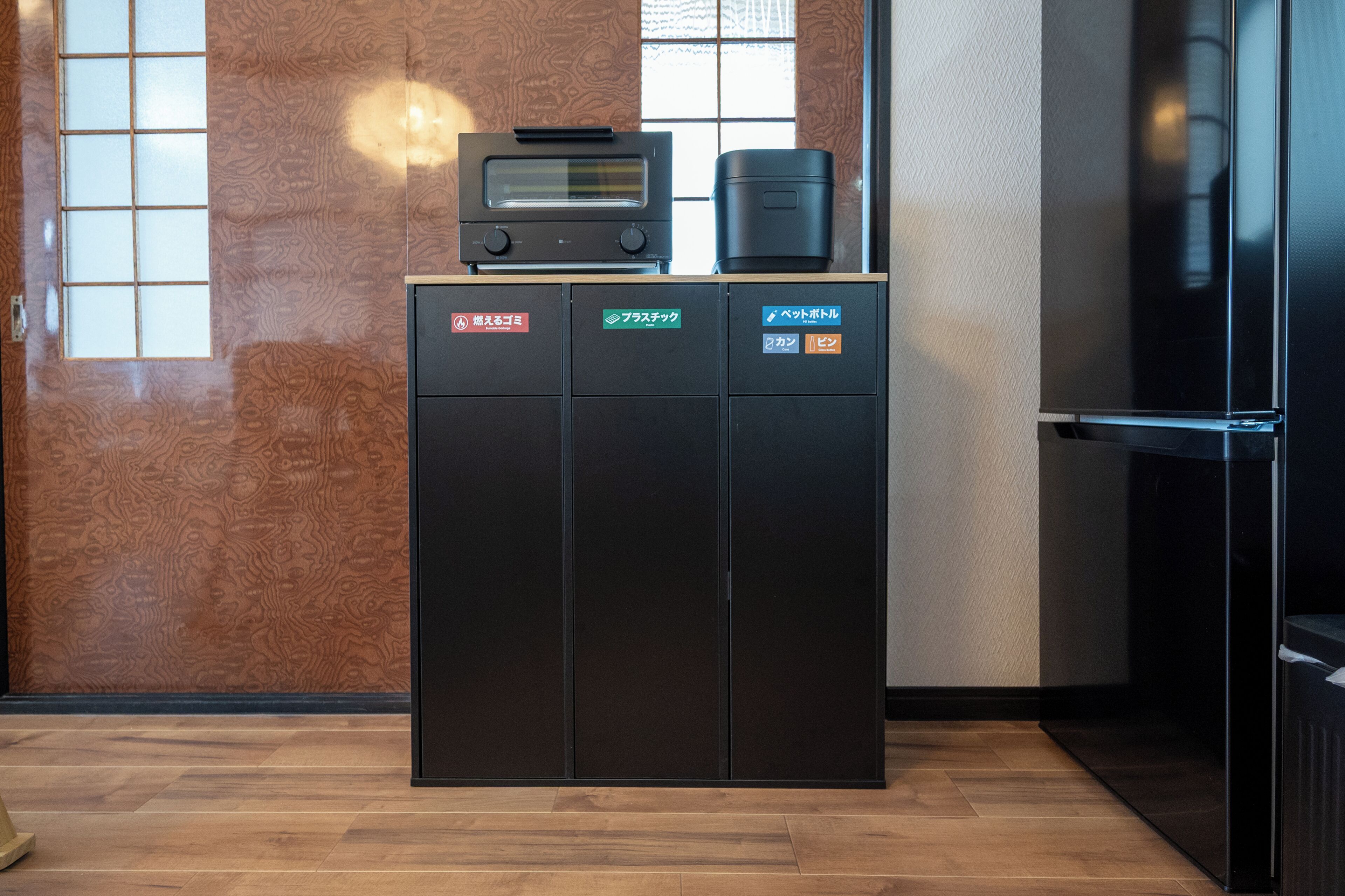 A kitchen with a built-in microwave, a coffee maker, and a refrigerator.