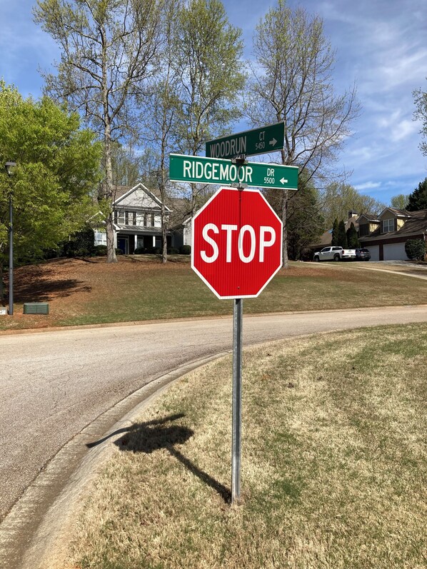 A stop sign at a street intersection with street signs for Woodrun and Ridgemoor.