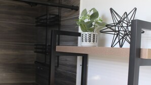 A bunk bed with a shelf holding a candle, a potted plant, and a geometric decoration.