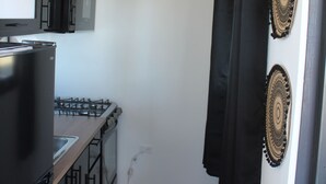 A compact kitchen with a refrigerator, stove, and microwave.