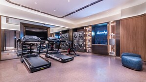 Ein modernes Fitnessstudio mit Laufbändern, Crosstrainern und einer Wäscherei.