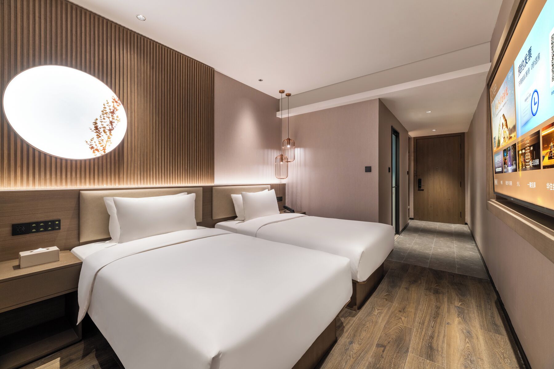 Een hotelkamer met twee bedden, een grote wandtelevisie en een wand van houten panelen.