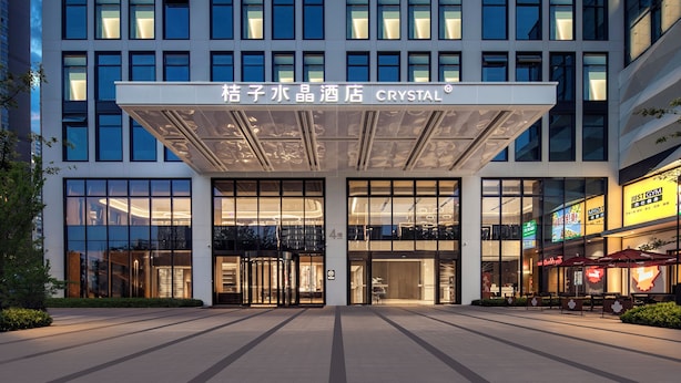A hotel entrance with a modern facade, large glass windows, and a prominent signage. - Crystal Hotel Hangzhou Binjiang Powerlong (Hangzhou)