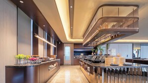 A modern kitchen with a curved island, built-in appliances, and a mezzanine with a railing. - Crystal Hotel Hangzhou Binjiang Powerlong (Hangzhou)