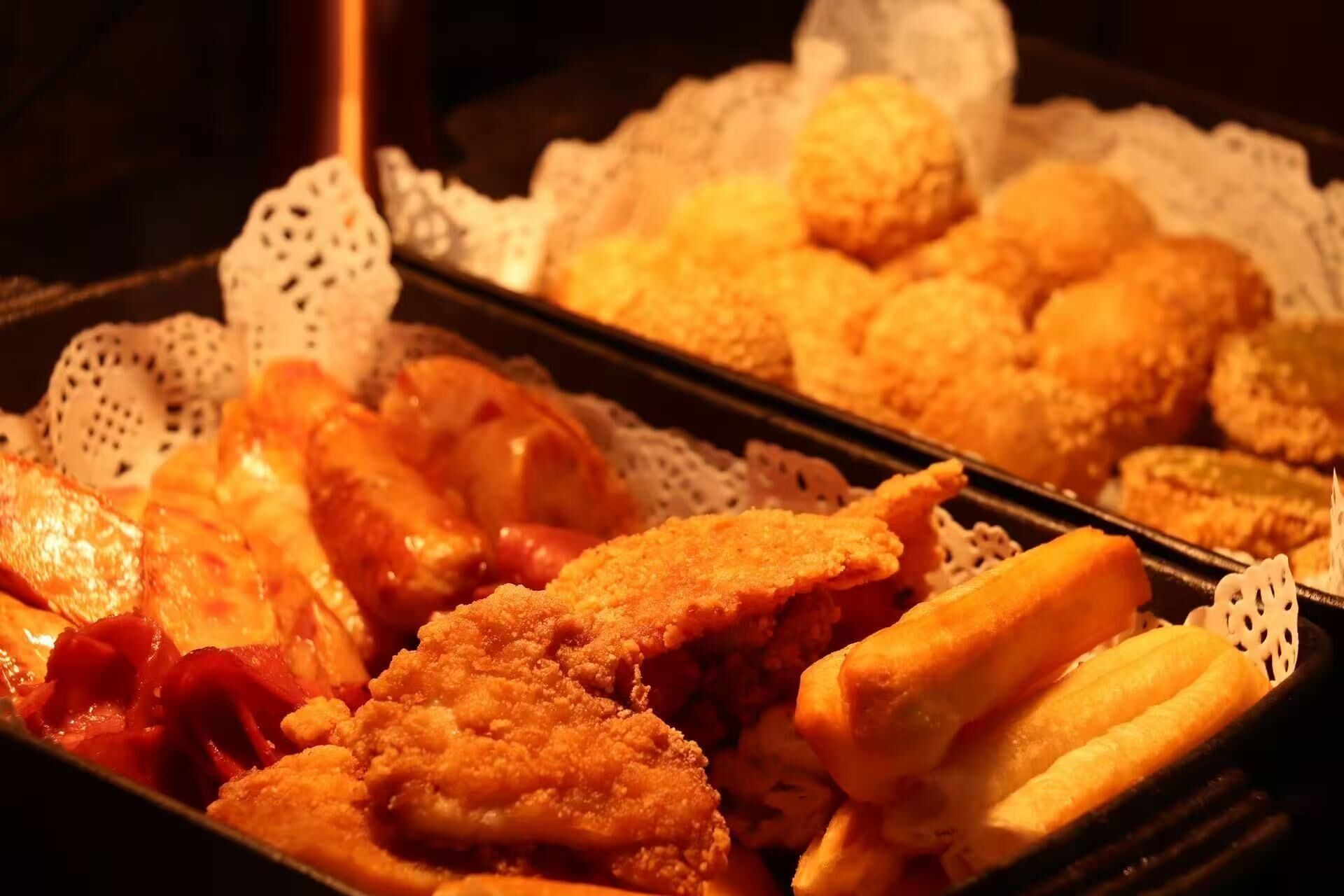 A tray of fried food items, including breaded chicken and fries.