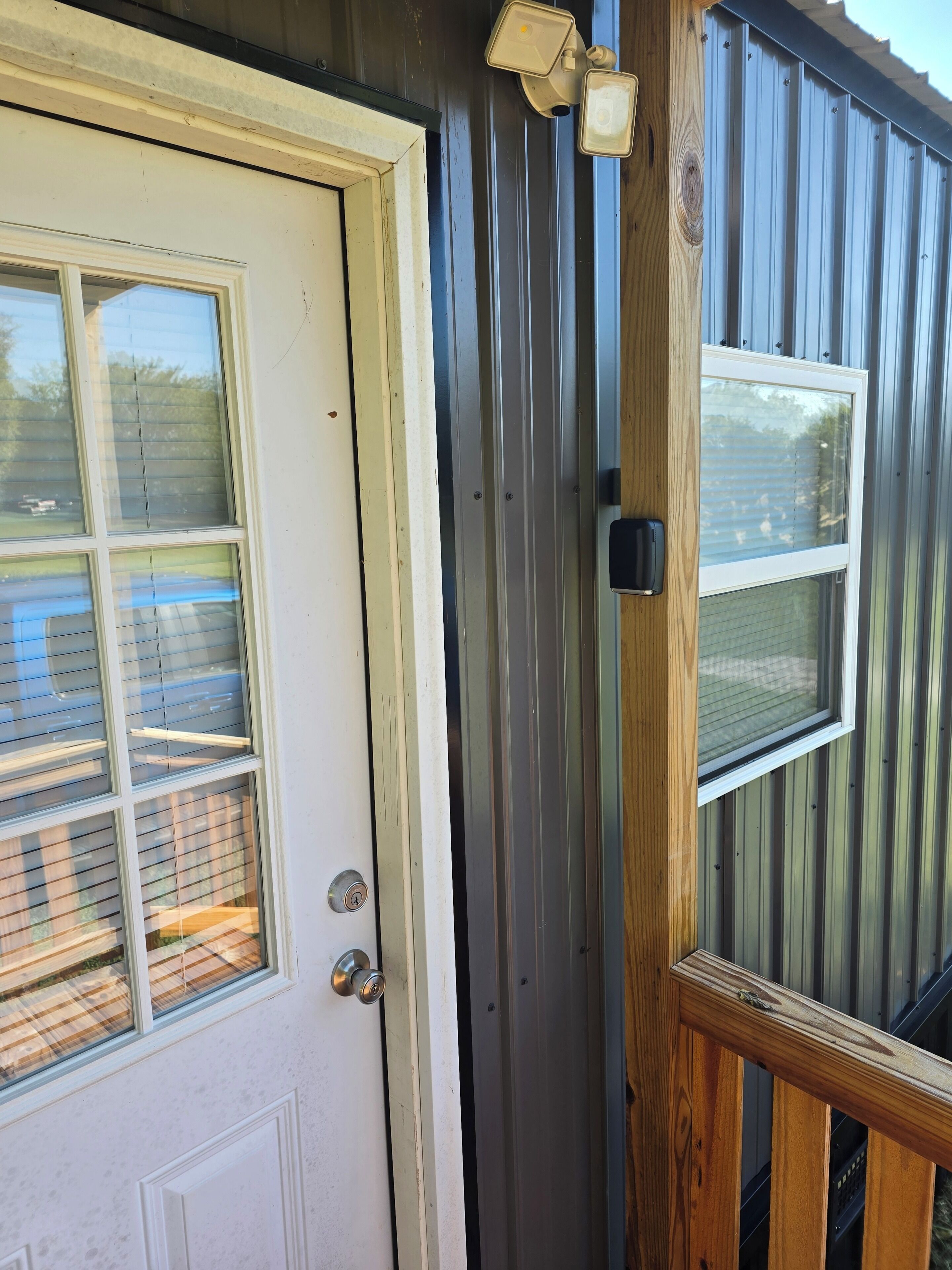 A door with a window, a metal exterior, and a wooden door frame.