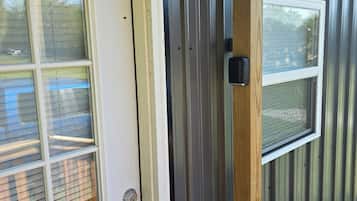 A door with a window, a metal exterior, and a wooden door frame.
