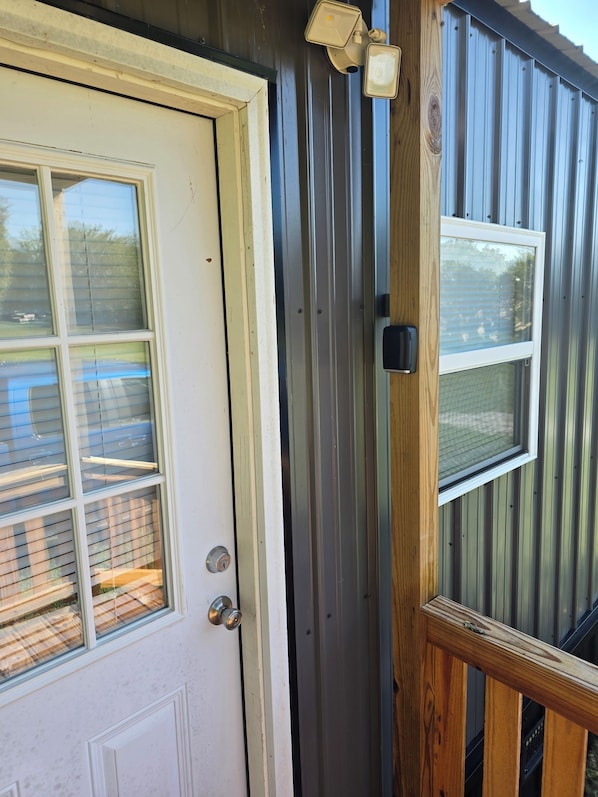 A door with a window, a metal exterior, and a wooden door frame.