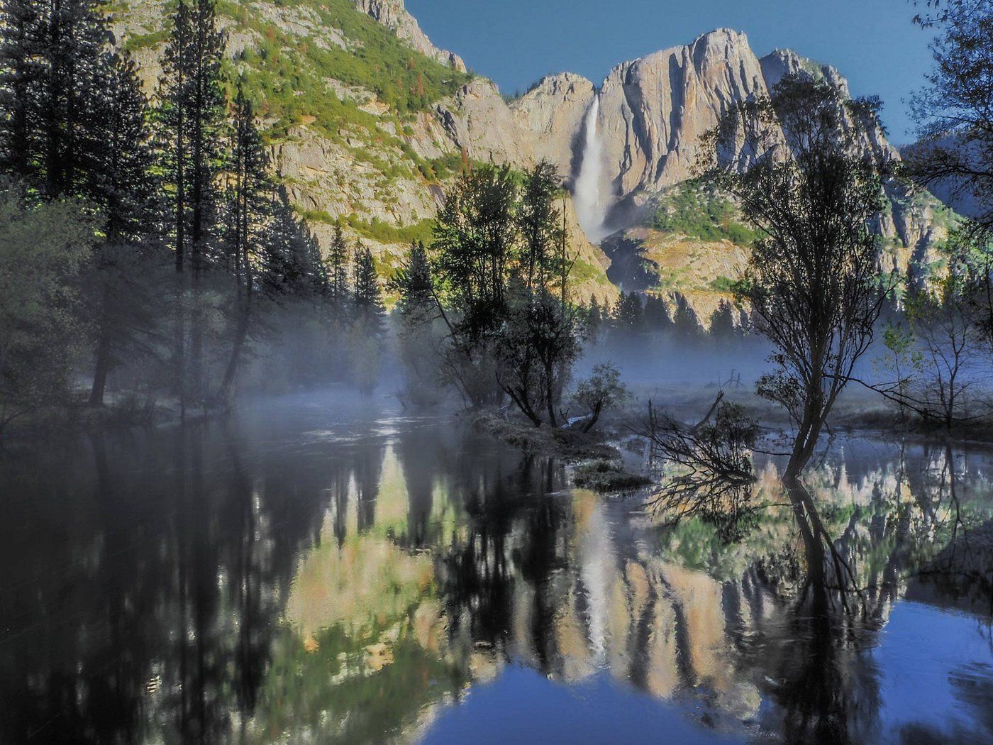 A serene lake with reflections of trees and mountains, surrounded by a forest.