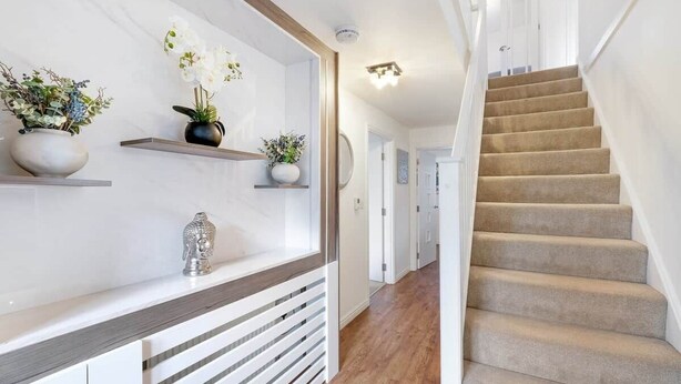 A staircase with beige carpet, white walls, and wooden flooring. - Entire 5 Bed home in Bristol United Kingdom (Pucklechurch)