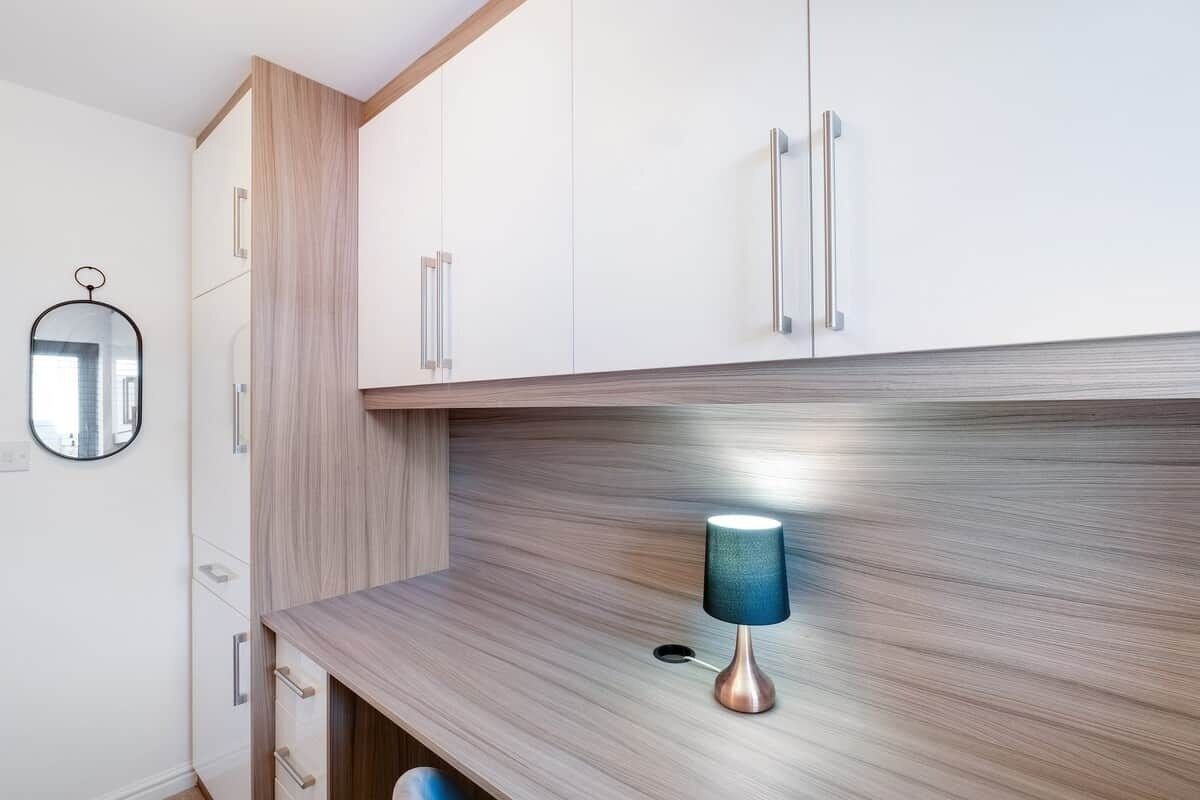 Eine moderne Küche mit Holzschränken, einer Arbeitsplatte und einer blauen Lampe.
