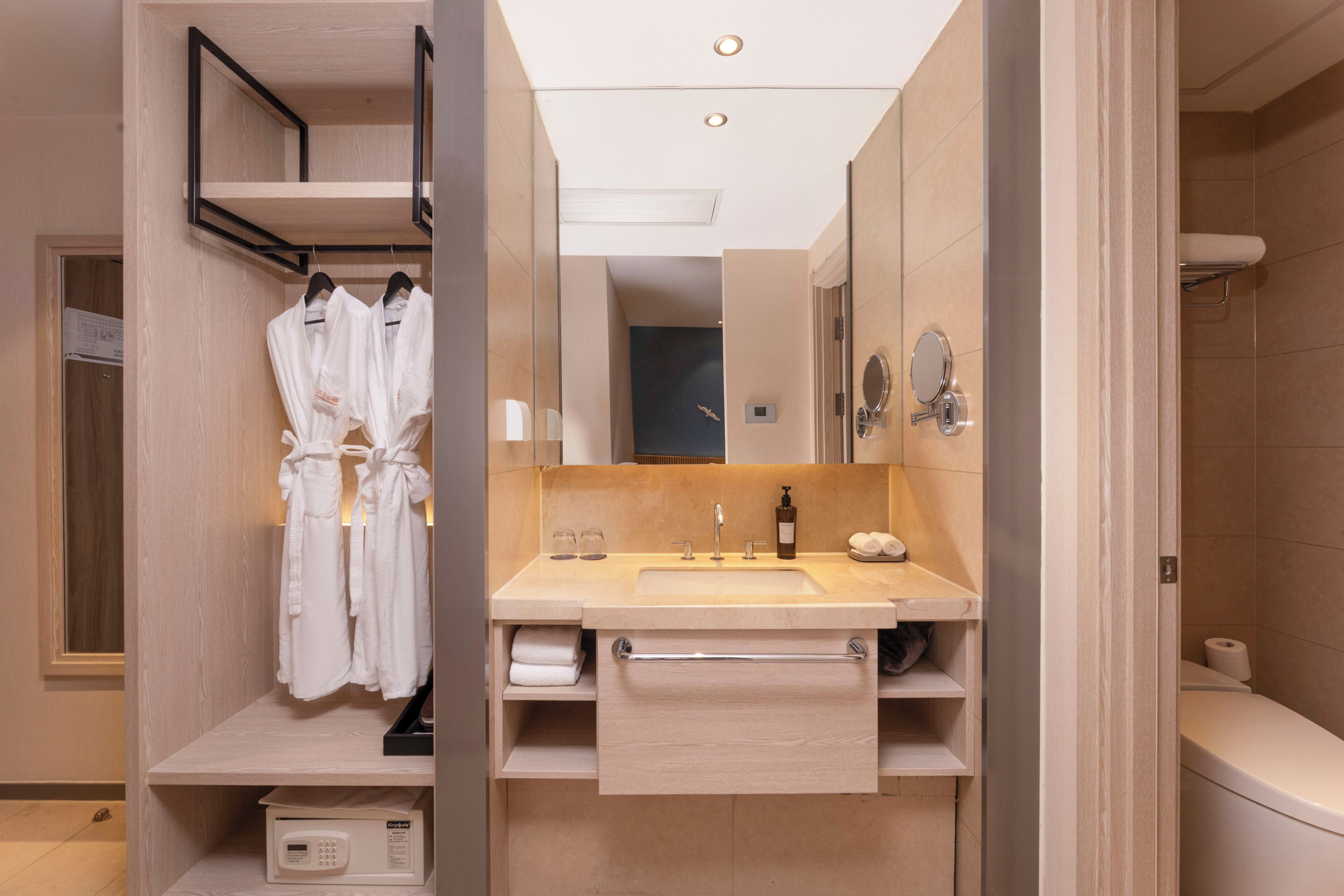 Un bagno moderno con lavandino, specchio, portasciugamani e zona doccia.