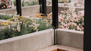 A modern outdoor seating area with concrete benches and a stone fire bowl. - Beachside Luxury Suite | Pool, hottub, Sleeps 6 (Kelowna)