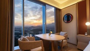 A hotel room with a large window, a round table, and two chairs. - Orange Crystal Hangzhou Tonglu Station (Hangzhou)
