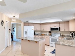 A modern kitchen with a central island, built-in appliances, and a pendant light. - 3BR Canal Home with Pool, Dock & Pool Table (Port Charlotte)