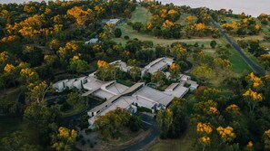 An aerial view of a modern building complex surrounded by dense forest and a golf course. - Geelong Conference Centre (Geelong)