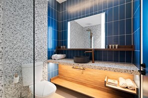 Un baño moderno con una bañera independiente, un espejo grande y un tocador de madera con lavabo.
