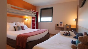 Habitación de hotel con literas, un escritorio, una silla y una ventana.