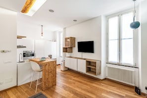 A modern kitchen with a wooden island, white cabinetry, and a built-in TV. - Lavagna Central Loft, Lavagna, Italy (Lavagna)