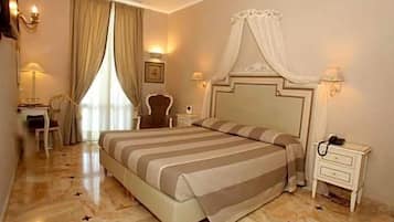 Una camera d'albergo con un letto grande, comodini, una scrivania e una sedia.