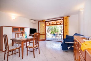 Ein Zimmer mit Essbereich, einer Sitzecke und einem Fernseher.