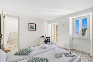 Ein Hotelzimmer mit Bett, Schreibtisch, Stuhl und Blick ins Freie.