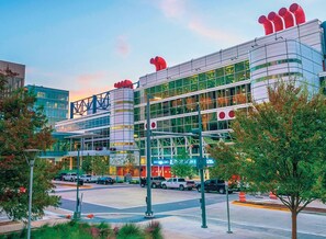 A modern building with a glass facade, multiple levels, and a distinctive red chimney-like structure. - Super Value Suite #2 - *4 km from FIFA Fan Fest* (Houston)