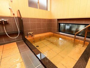 Baño con bañera, ducha y ventana.