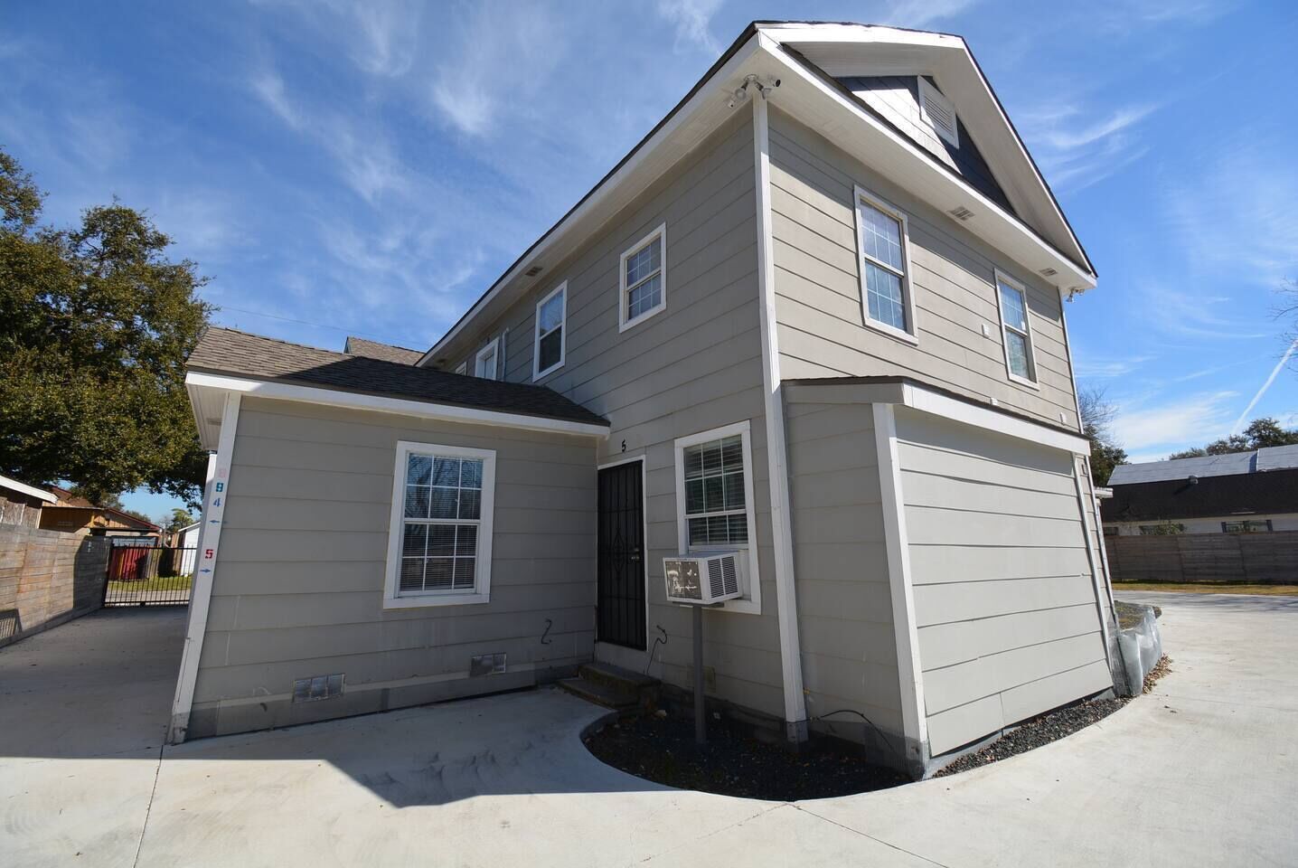A two-story house with a garage, a small porch, and a clear sky.