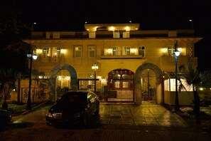 A large, well-lit building with a prominent entrance, a car parked in front, and a paved driveway. - Bella View Lounge (Islamabad)