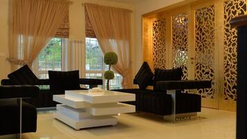 A spacious living room with a chandelier, two sofas, a coffee table, and a decorative wall panel.