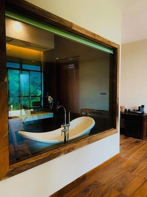 A modern bathroom with a freestanding bathtub, a large mirror, and a wooden floor. - Oak Ray Tea Bush Ramboda (Ramboda)