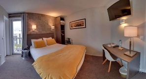 A hotel room with a bed, desk, chair, and a large window. - Hotel Acadie Les Ulis (Villebon-sur-Yvette)