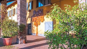 Un edificio con facciata in mattoni, una parete gialla con decorazioni e una porta con un cartello sopra.