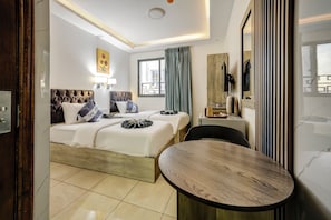 A hotel room with a bed, a round table, a TV, and a window with curtains. - Down Town Hotel Aqaba (Aqaba)