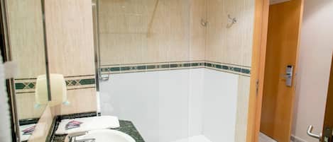 A bathroom with a shower, a sink, and a toilet.