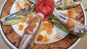 Un plato de comida con diversos pescados y verduras.