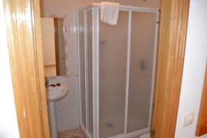 A bathroom with a shower enclosure, a sink, and a mirror. - Hotel Restaurante Las Camelias (Coana)