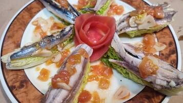 Un plato de comida con diversos pescados y verduras.