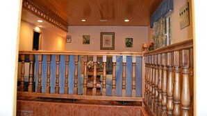 Una escalera de madera con barandilla azul que da a una plataforma.