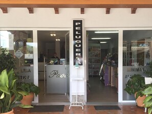 Vitrine com uma placa que diz 'PELQUER' e um balcão de exposição.